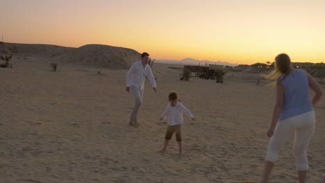 Familie-Spielt-Fußball-Am-Strand