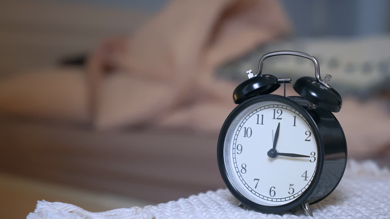 Une femme stressée et nerveuse ne parvient pas à dormir près d'un réveil, souffrant d'insomnie, symbolisant les remèdes pour le repos, cherchant des médicaments pour un traitement de santé et un concept de rétablissement.