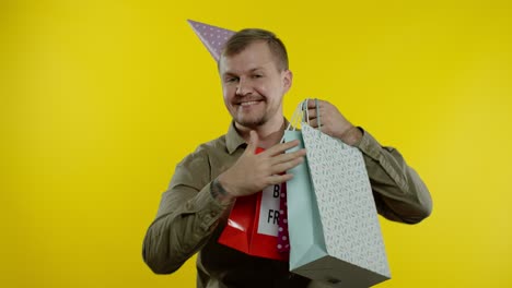 hombre levantando bolsas de compras, bailando, celebrando, disfrutando de descuentos en el viernes negro vacaciones de venta