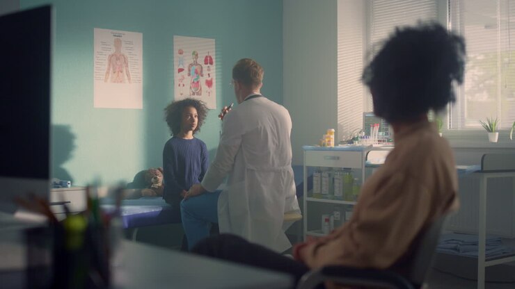 Man doctor checking preteen kid reaction in office clinic. African mom waiting.