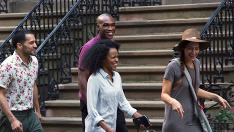 group of friends walking along urban street in new york city