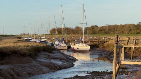 sailing boats docked in the estuary with evening golden sunlight