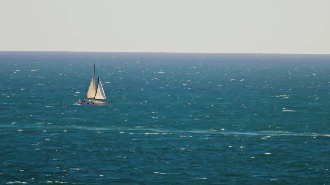 Distant view of a sailing boat moving on the sea