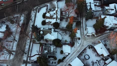 2-2 aerial forward birds eye view over winter urban luxury home during a sunset tree tip lit branches with wet snowy slushed roads light traffic in a rich residential community with curvy sideroads