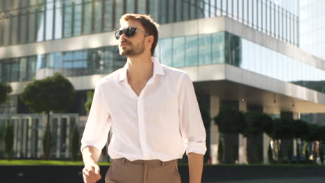 stylish man in white shirt and sunglasses in a city