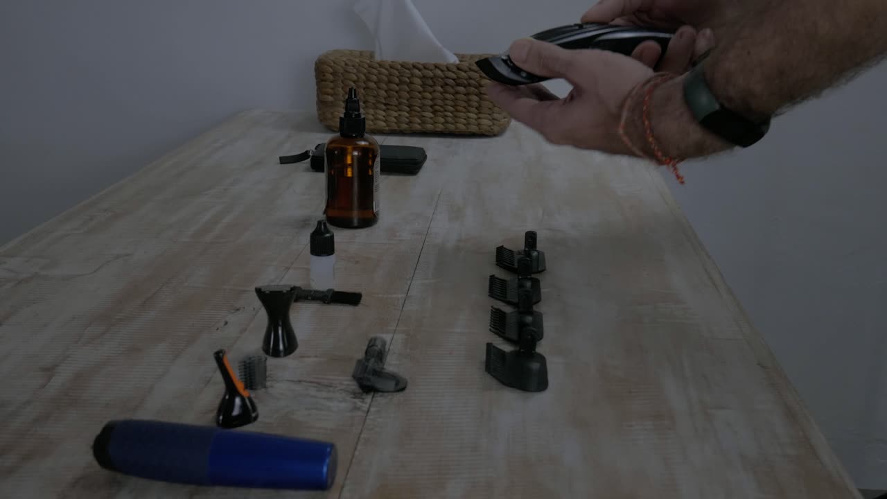 un hombre caucásico conectando un espaciador a una afeitadora eléctrica