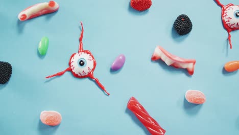 close up view of multiple halloween toys and candies against blue background