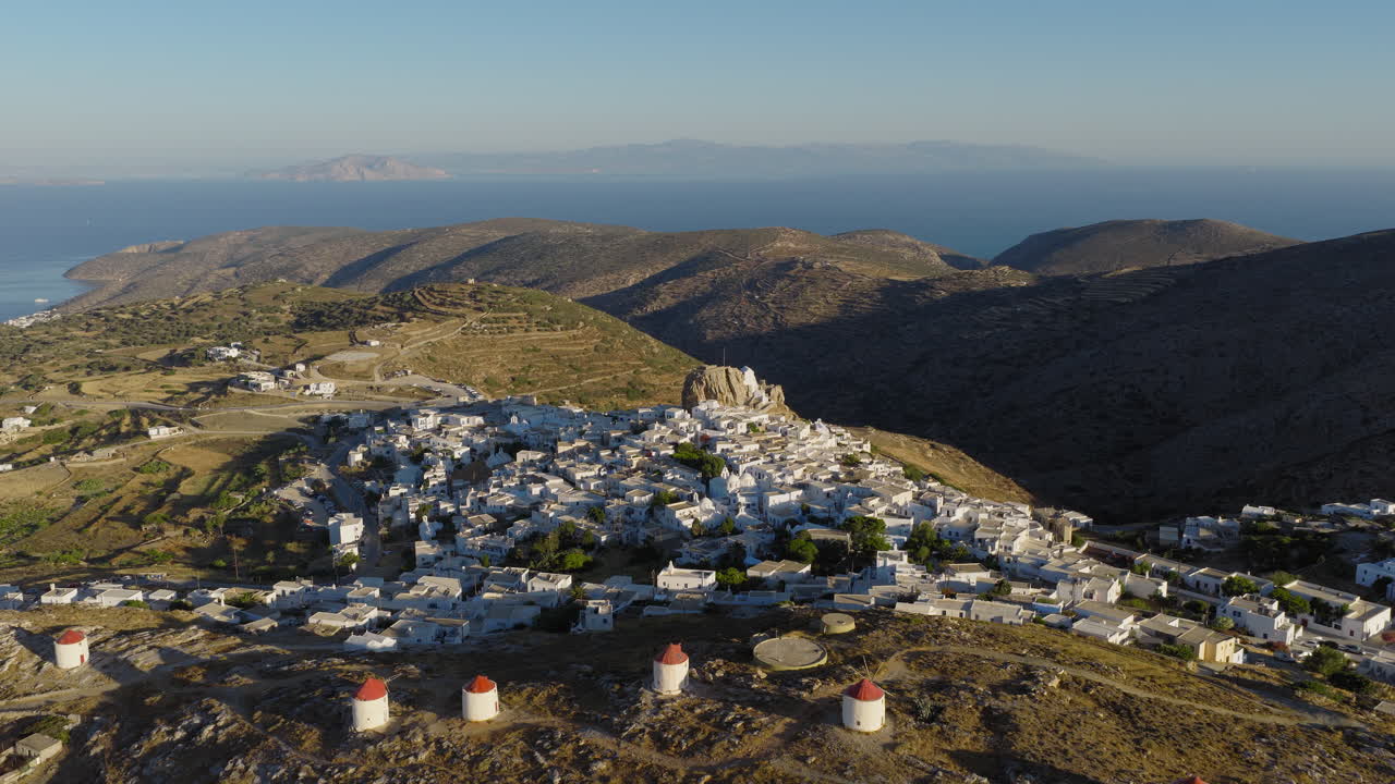 Aerial view of Chora illuminated at dawn with white Cycladic houses, Amorgos, Luxury tourism in Greece