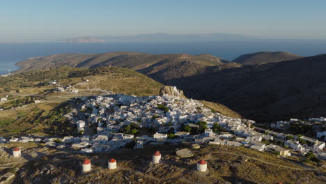 aerial view of chora illuminated at dawn with white cycladic houses, amorgos, luxury tourism in greece