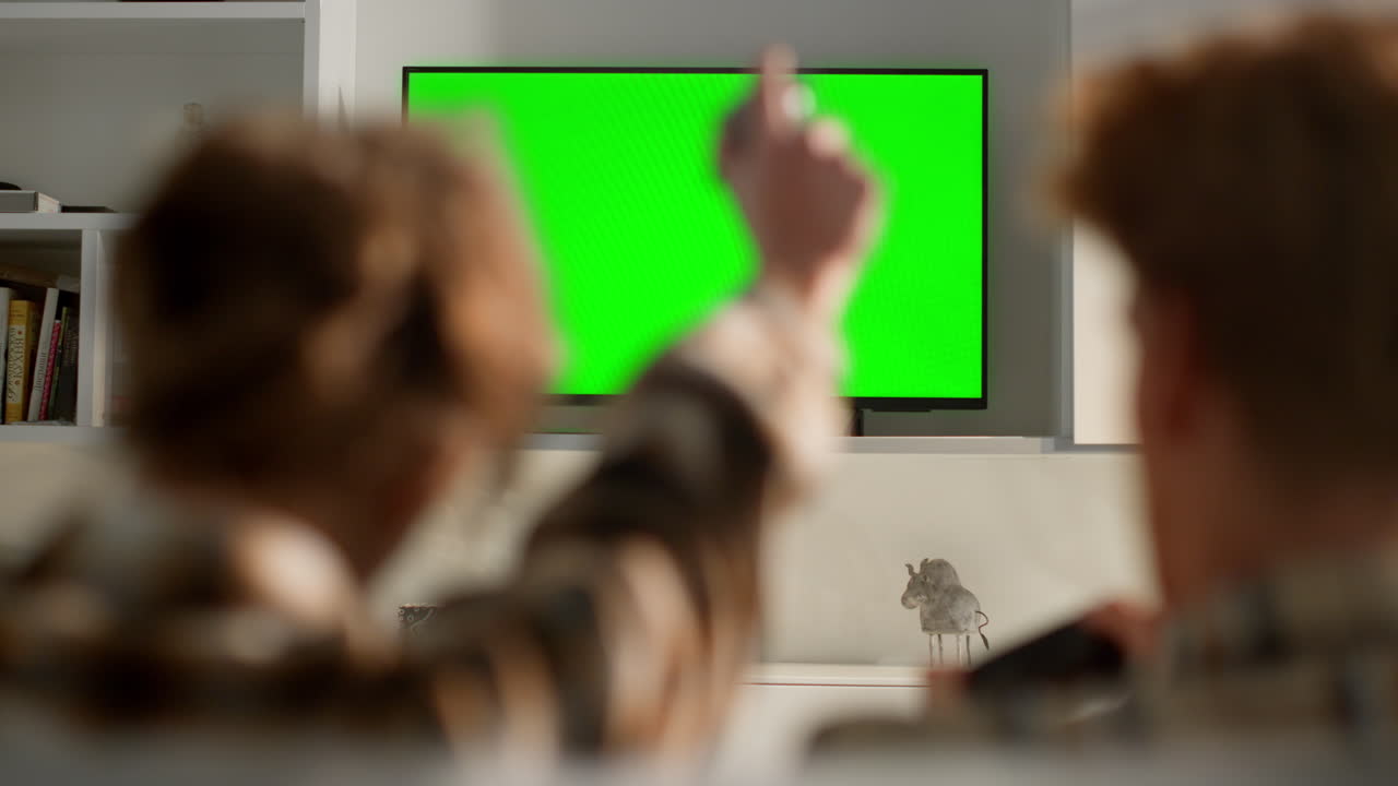 비디오 게임 tv 크로마 키 세트 거실에서 알려지지 않은 여성이 승리를 축하하고 있습니다.