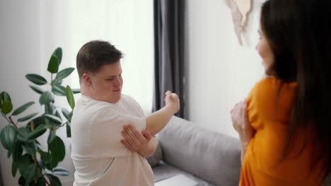 a man with down syndrome and instructor - training together at home, doing stretching exercises