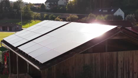 módulos fotovoltaicos de vidrio al atardecer en un techo de una granja