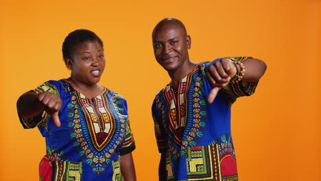 ethnic man and woman showing thumbs down symbol