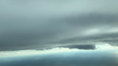 flying under a dramatic sky covered with stormy clouds over the sea