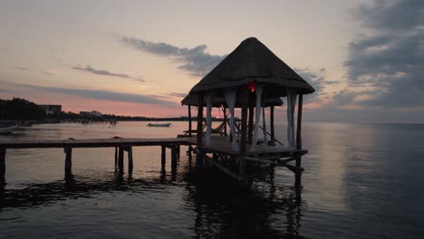 Aerial-view-of-a-beautiful-wooden-pier-during-sunset-in-Alea-Tulum,-Mexico