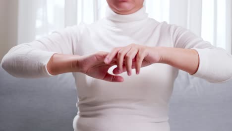 Young-woman-performing-self-hand-massage-during-break-in-office