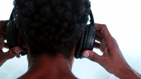 back of person putting on headphones, man wearing noise cancelling headphones