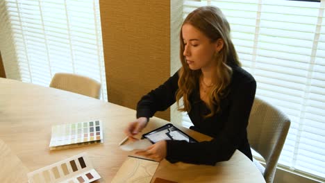 un estilista de interiores que trabaja con ejemplos y tabletas