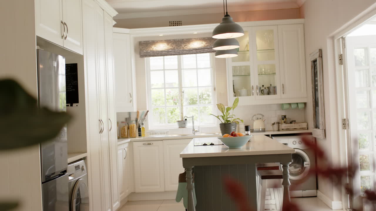 Isola della cucina, lampade, mobili, frangia e finestre in una cucina soleggiata, al rallentatore