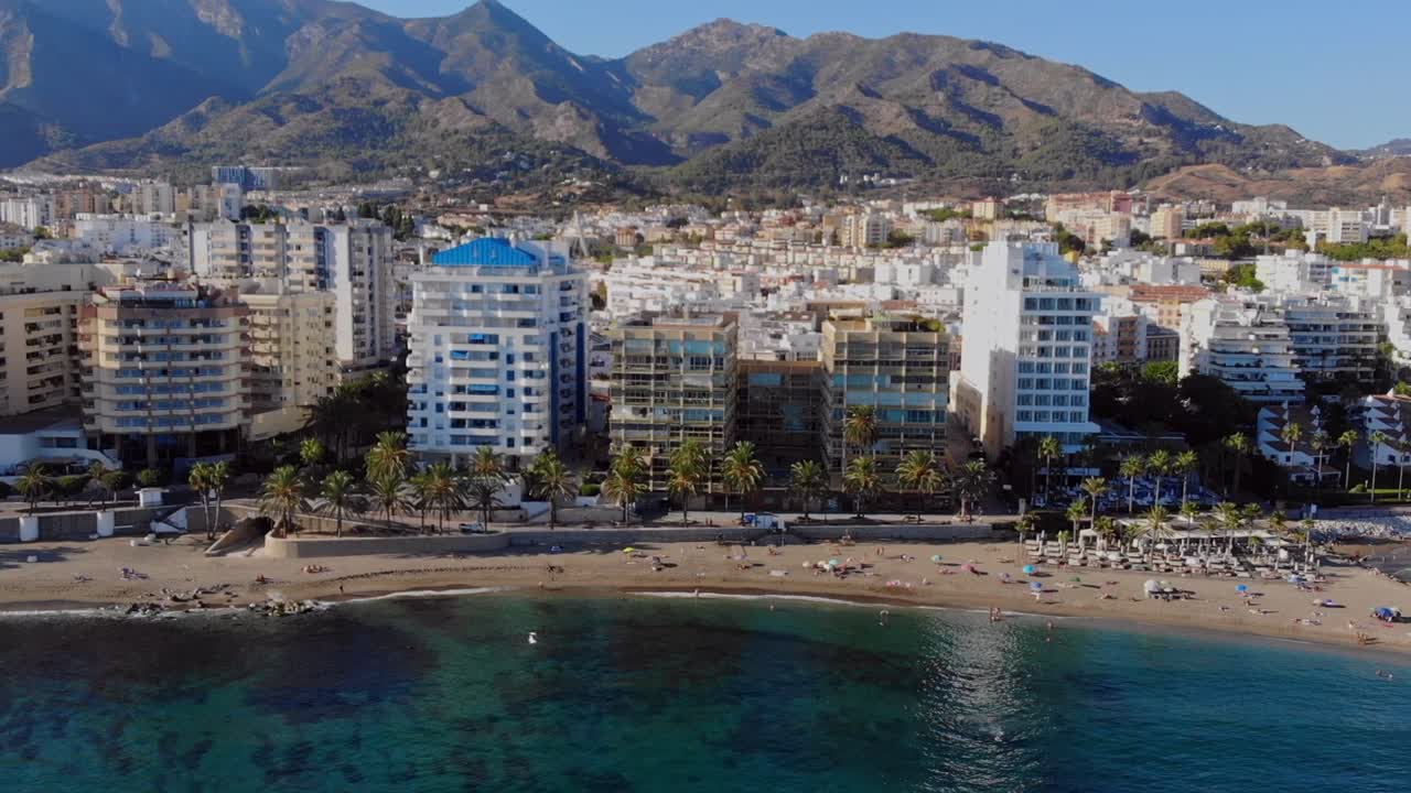 drone disparado paralelamente de lado, filmando la playa en marbella, españa