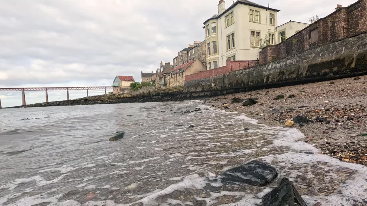 파도가 부드럽게 바위가 있는 해안에 부히고