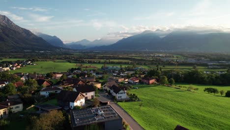 luftaufnahme von liechtenstein mit häusern auf grünen feldern im alpen-bergtal