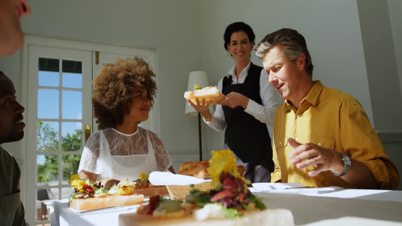 Smiling waitress serving food to customers