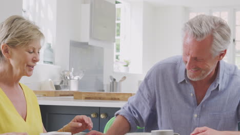 Pareja-De-Jubilados-Sentados-Alrededor-De-La-Mesa-En-Casa-Desayunando-Saludablemente-Con-Fruta-Fresca-Juntos