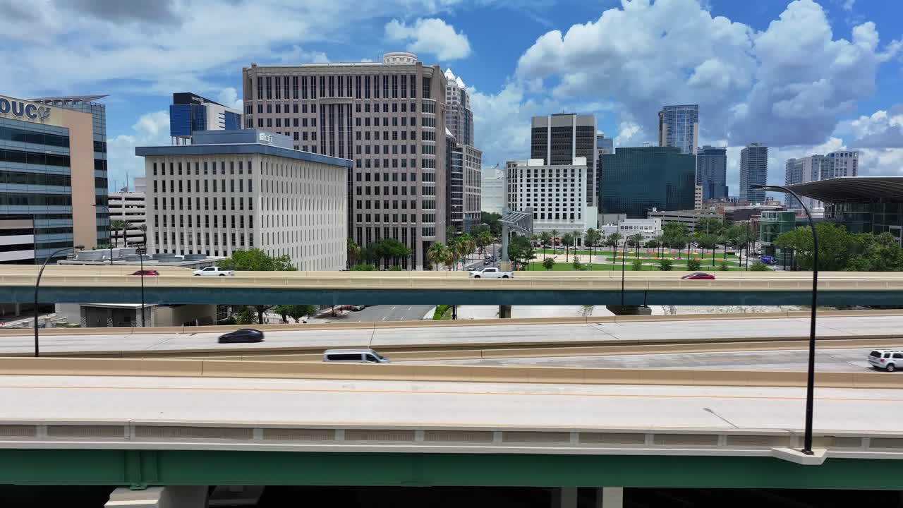 Orlando highways and skyscrapers in downtown on bright day with puffy clouds. Close up aerial shot.