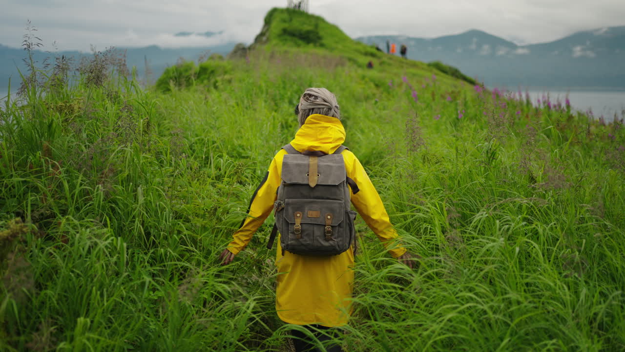 Woman Hiking Through Lush Grass on an Island