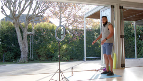 African-american-male-fitness-vlogger-exercising-and-filming-at-home,-slow-motion