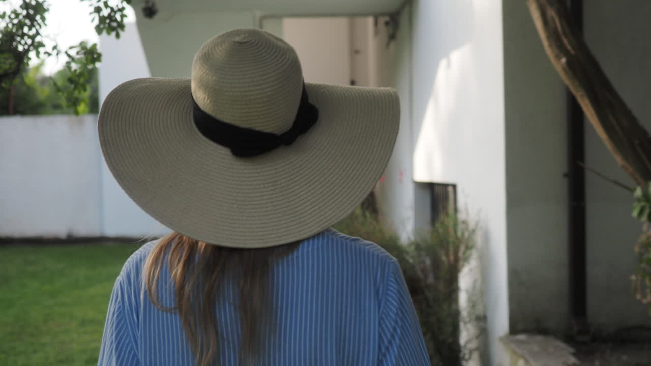 vista trasera de una mujer caminando en el jardín