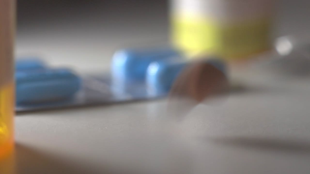 las pastillas ovaladas caen sobre la mesa blanca