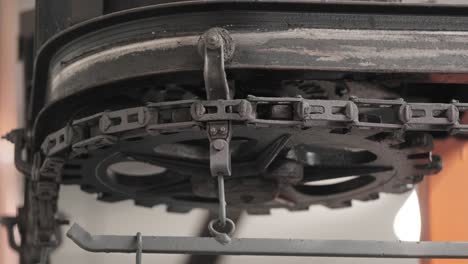 mechanical gear with metal chain rotating slowly in a factory