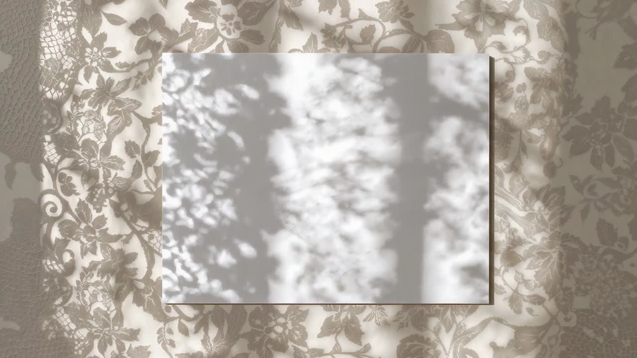 Luce solare tra le foglie che proietta una luce screziata e fluttuante su un cartoncino bianco su una stoffa a fiori