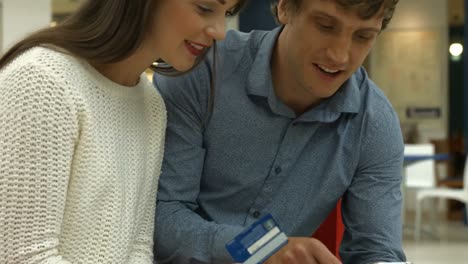 Couple-with-smartphone-and-credit-card-discussing-