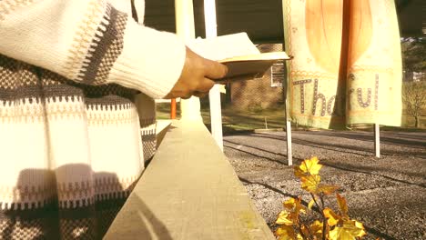 Black-woman's-hands-only-holding-and-reading-bible-on-a-cold-sunny-day