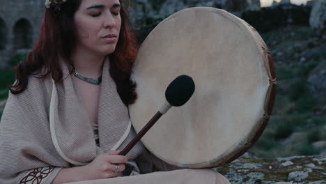 Mujer-Espiritual-Tocando-Pacíficamente-Un-Tambor-Chamánico-En-Un-Hermoso-Pueblo-Medieval.-Primer-Plano-De-Detalle.