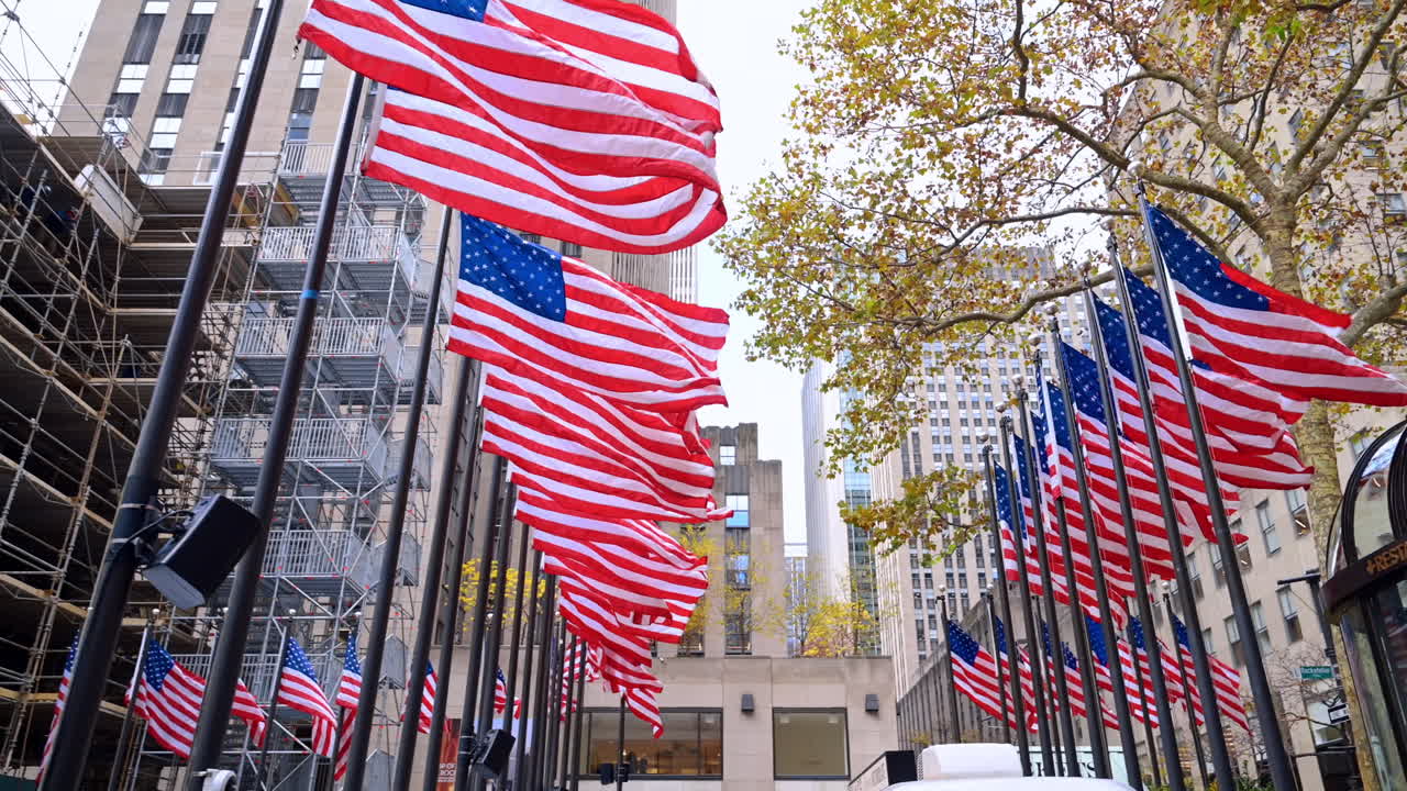 New York, USA, 8 novembre 2025: alberi autunnali e bandiere a Rockefeller Plaza. Alberi autunnali e bandiere ben visibili incorniciano l'area di Rockefeller Plaza, ricca di attività