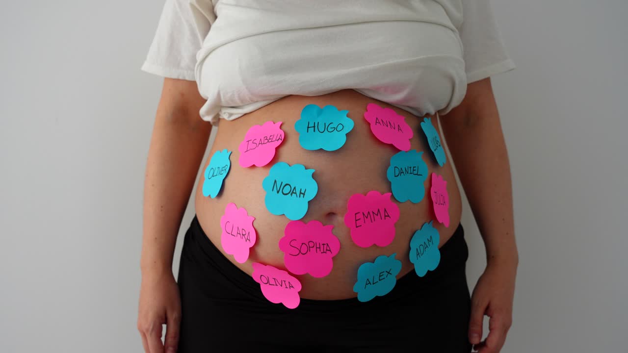 Pregnant belly with baby name ideas on sticky notes, gently moving side to side