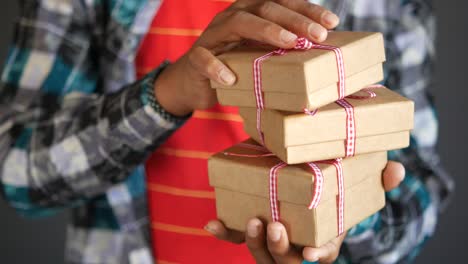 person holding a stack of wrapped gifts