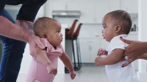padres alentando al bebé hijo e hija a interactuar entre sí