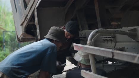 truck repairmen working underneath a truck