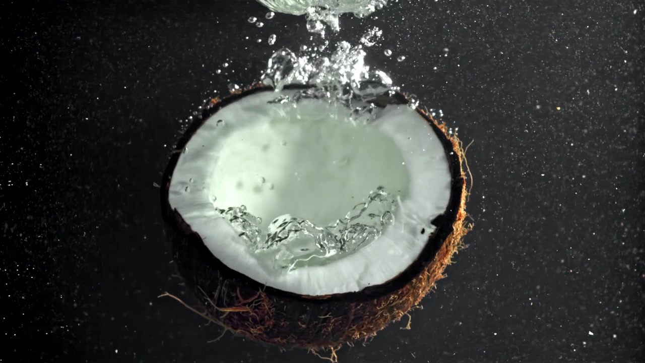 Slow Motion Water Splashing into a Half Coconut
