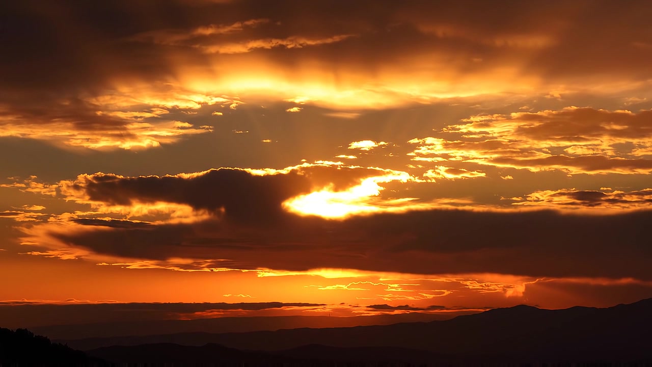 Goldene Sonnenstrahlen durchbrechen dramatische Gewitterwolken bei Sonnenuntergang