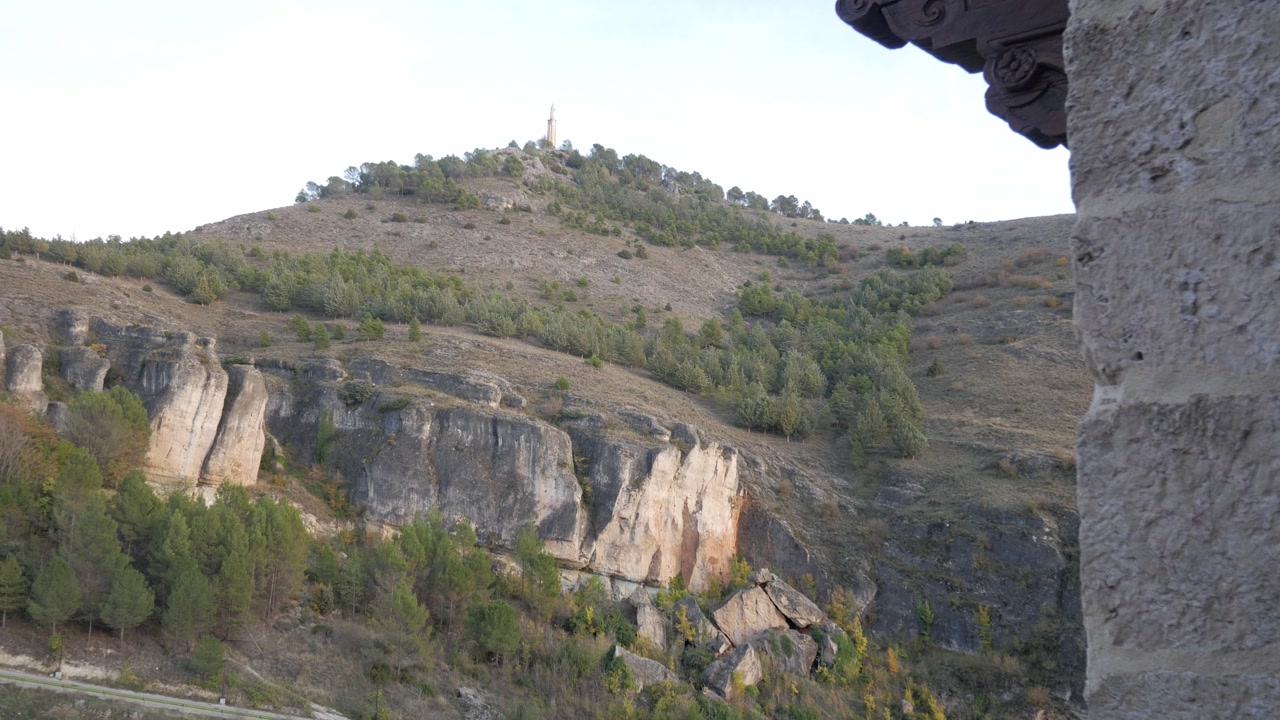 Peaceful hillside view in Cuenca, Spain with trees and distant peak