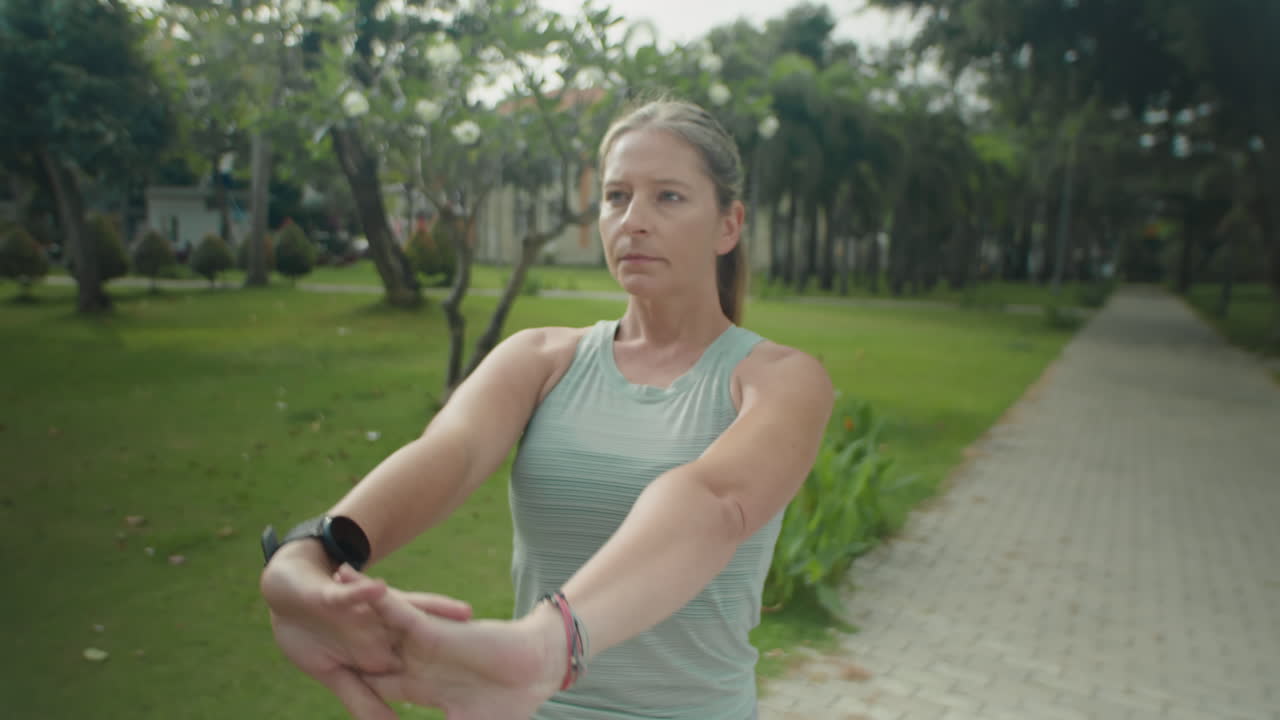 Sporty Woman Warming Up before Outdoor Training in Park