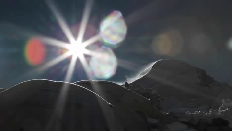 sun rising from behind tents and cloud