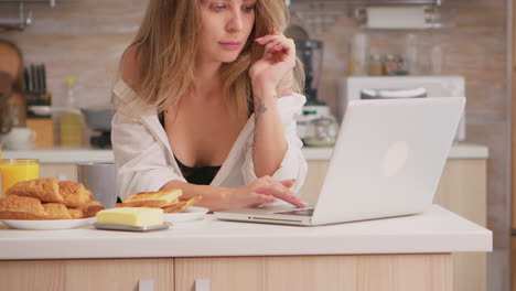 Sexy-Hausfrau,-Die-Laptop-Benutzt