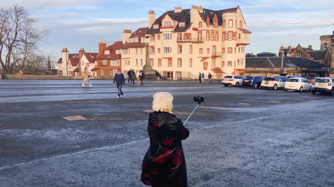 Une femme asiatique âgée utilisant une perche à selfie sur un site touristique